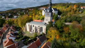 Uma igreja com uma torre imponente e um edifício menor com relógio.