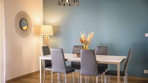 Un comedor con una mesa, sillas, una lámpara y un espejo decorativo.