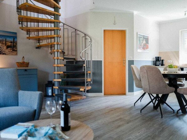 Un interior moderno con una escalera de caracol, un comedor y una sala de estar.