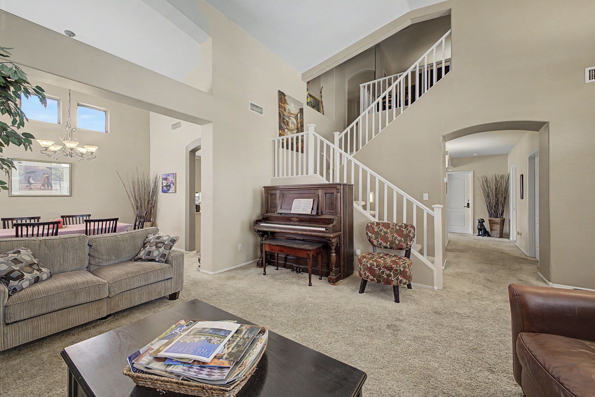A spacious living room with a piano, a sofa, and a coffee table.