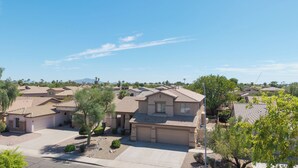 A residential area with houses featuring similar architectural styles, including pitched roofs and stucco exteriors. - Spacious 6-BR Furnished 30 day rental! Great Pool! (Chandler)