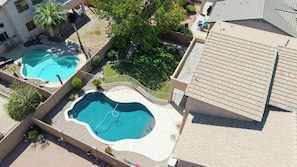 Et boligområde med to swimmingpools, en overdækket terrasse og en bygning med et tagtækket tag.