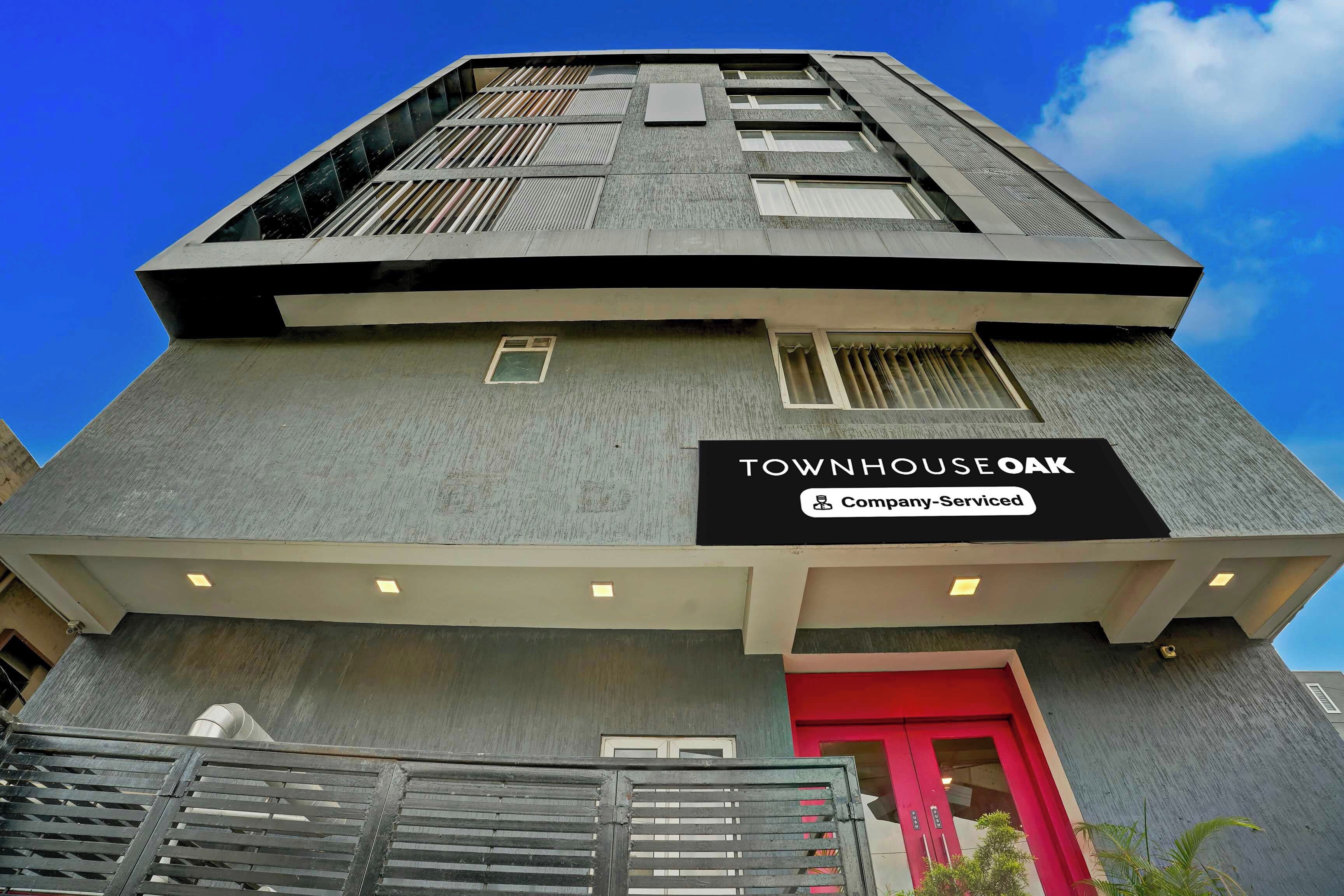 A building with a sign reading 'TOWNHOUSE OAK' and 'Company-Serviced'.