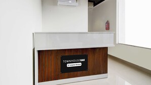 En receptionsdisk med et skilt, der angiver 'Townhouse Oak' og 'Company Serviced'.