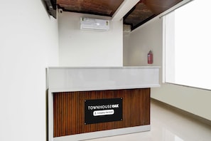 Un mostrador de recepción con un cartel que indica 'Townhouse Oak' y 'Company Serviced'.