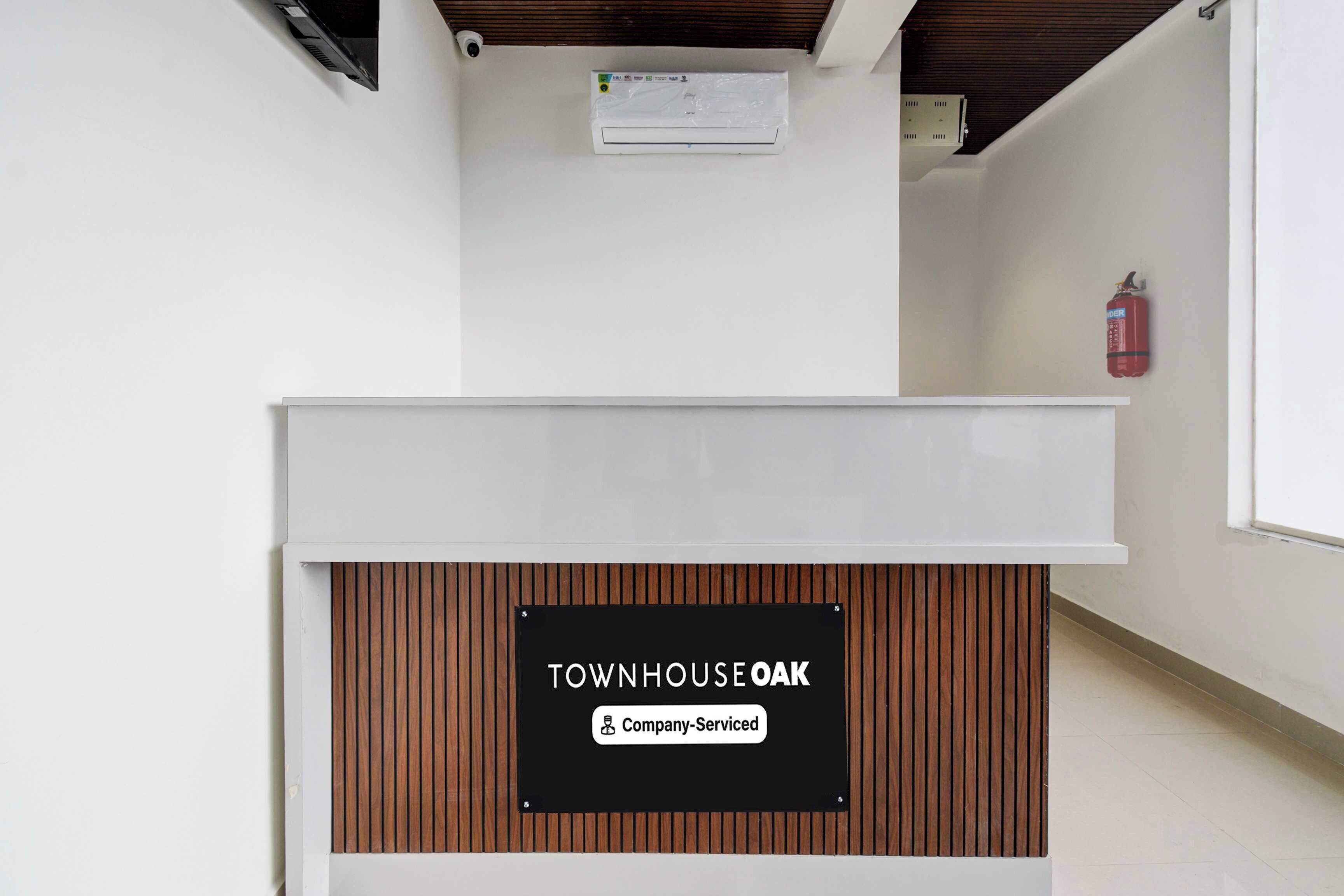 A reception desk with a sign indicating 'Townhouse Oak' and 'Company-Serviced.'
