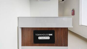 A reception desk with a sign indicating 'Townhouse Oak' and 'Company-Serviced.'