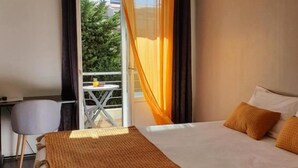 Een hotelkamer met een bed, een tafeltje en een stoel.