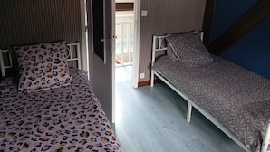 A room with two beds, one with a leopard print bedspread and the other with a patterned bedspread. - Lourdes: 5-Bedroom Duplex for 15 Guests, Central Location Near the Shrine (Lourdes)