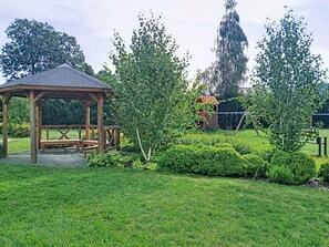 A gazebo, a swing set, and well-maintained hedges in a park. - Cosy apartment for 4 guests with WIFI, TV and pets allowed (Dvůr Králové Nad Labem)