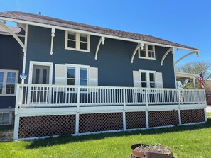 A two-story house with a porch, white shutters, and a small American flag. - Historic 5-bedroom house in Swanton perfect for family getaways (Swanton)