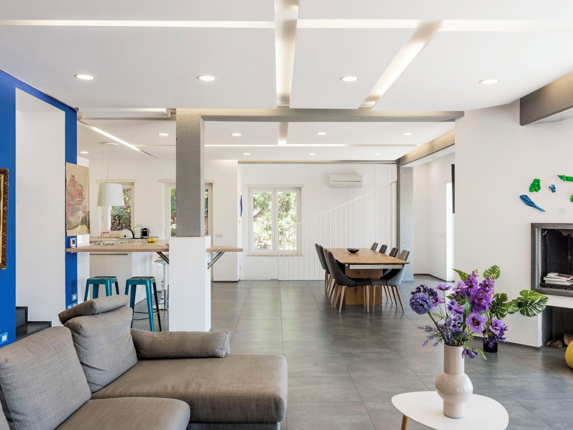 A modern interior with a dining area, kitchen, and seating space.
