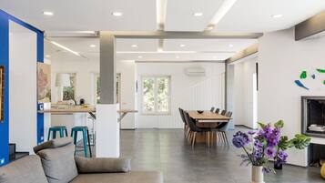 A modern interior with a dining area, kitchen, and seating space.