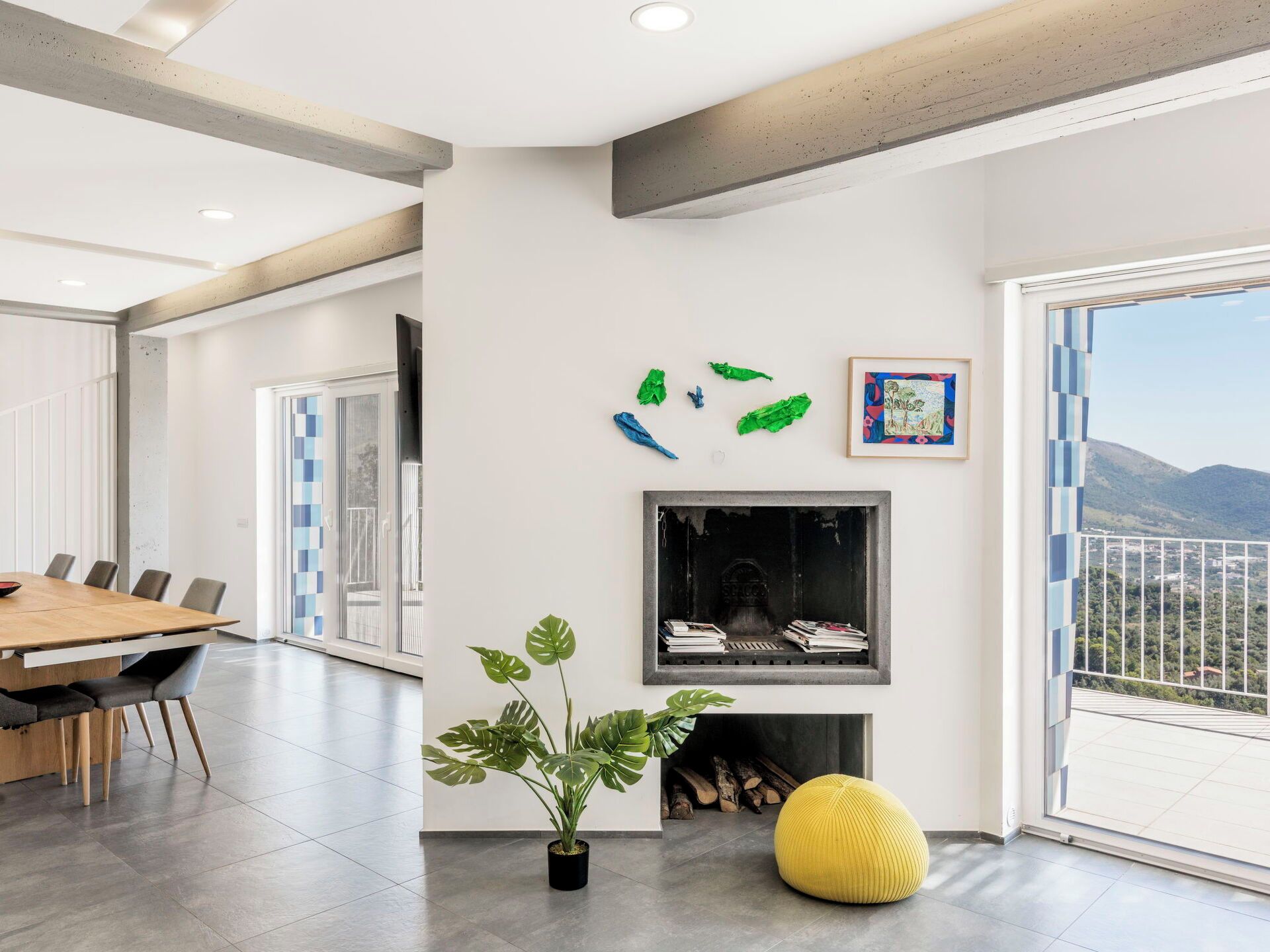 A modern living room with a dining area, a fireplace, and a view of the outdoors.