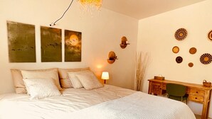 Une chambre avec un grand lit, un bureau et des éléments de décoration fixés au mur.