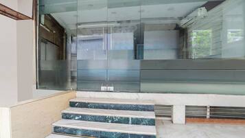 A modern interior with a glass door entrance, marble steps, and a clean, minimalist design.