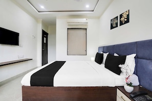 A modern hotel room with a large bed, a flat-screen TV, a bedside table with a phone, and a wall-mounted air conditioning unit. - Townhouse Bhopal DB City Mall (Bhopal)