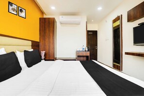 A hotel room with a large bed, a wooden wardrobe, a desk with a kettle, and a television on the wall. - Townhouse Bhopal DB City Mall (Bhopal)