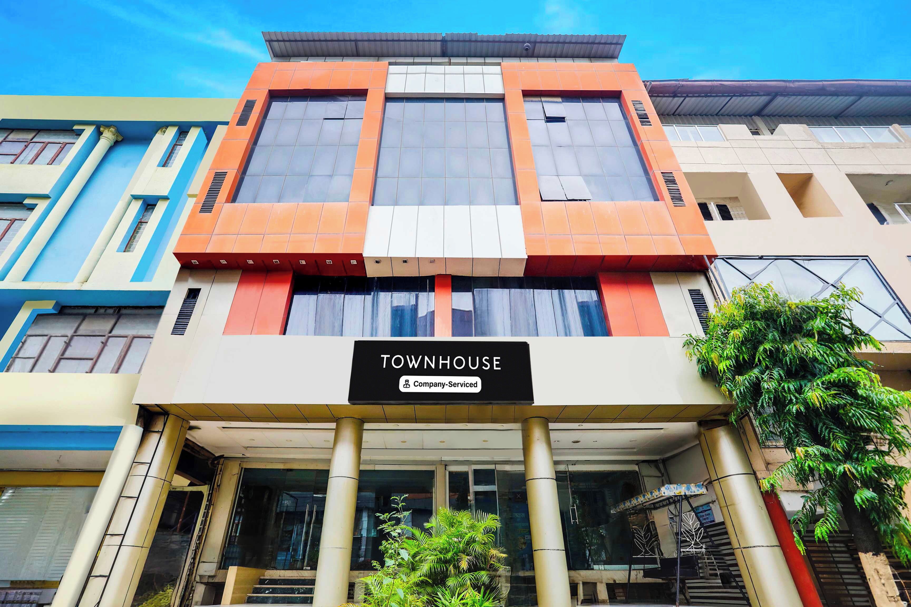 A multi-story building with a sign reading 'TOWNHOUSE Company-Serviced'.