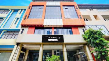 A multi-story building with a sign reading 'TOWNHOUSE Company-Serviced'.