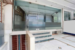 A modern interior with a glass partition, a staircase, and a white wall. - Townhouse Bhopal DB City Mall (Bhopal)