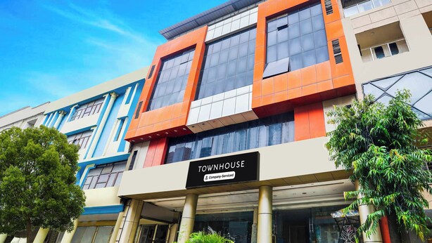 Moderni rakennus, jonka kyltissä lukee: ”TOWNHOUSE – palveluita tarjoava yritys”.
