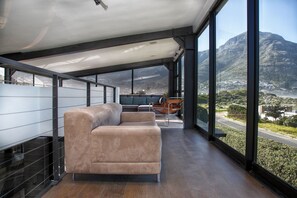 Ein modernes Interieur mit einem großen Fenster, einem Sofa und einem Essbereich.