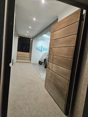 Ein modernes Interieur mit einem Auto in einer Garage, einer Treppe und einer Holztür.