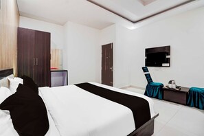 A hotel room with a bed, a desk, a television, and a wardrobe. - Townhouse Oak  Faizabad Road (Lucknow)