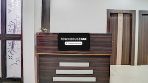 En receptionsdisk med et skilt, der står 'TOWNHOUSE OAK Company-Serviced'.