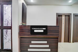 A reception desk with a sign that reads 'TOWNHOUSE OAK Company-Serviced'. - Townhouse Oak  Faizabad Road (Lucknow)
