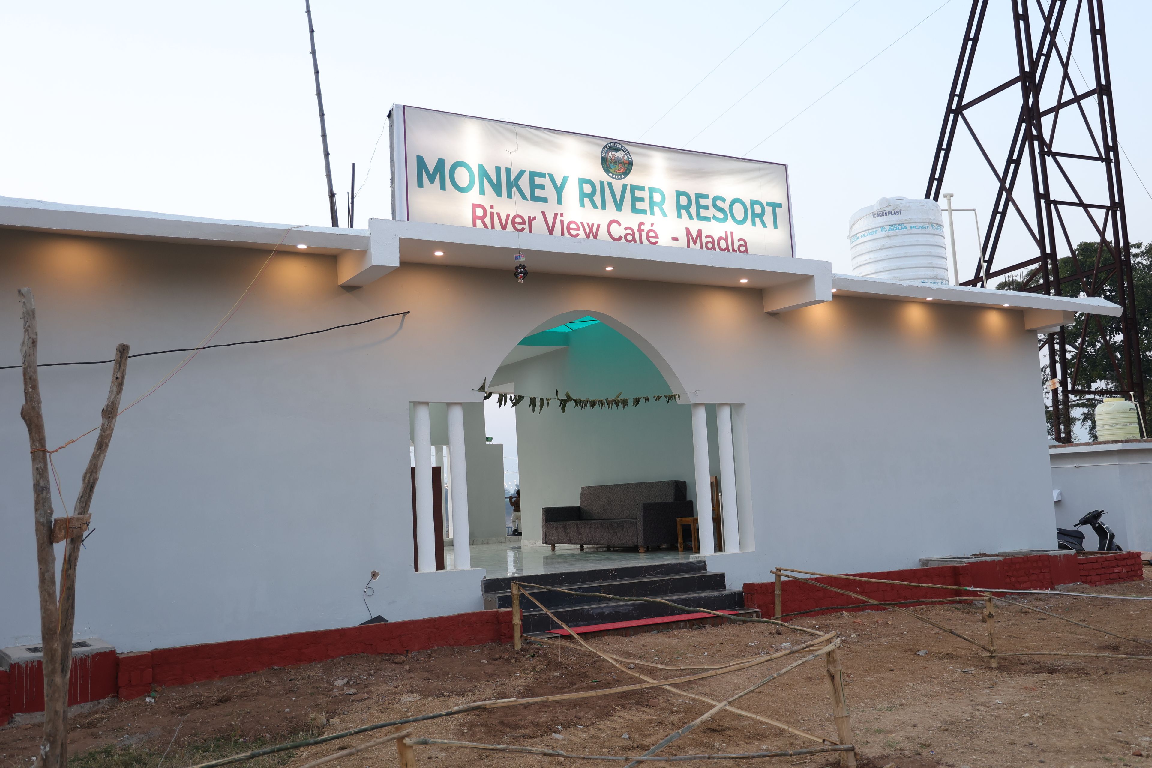 A building with a sign for 'Monkey River Resort' and 'River View Café - Madla'.