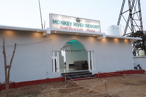 A building with a sign for 'Monkey River Resort' and 'River View Café - Madla'.