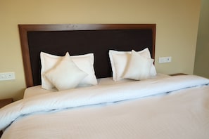 A bed with a wooden headboard and two pillows. - Monkey River Resort  (Madla)
