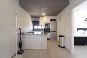 A compact kitchen with a microwave, oven, and refrigerator. - Apartamento Naru (San Pedro del Pinatar) (San Pedro del Pinatar)