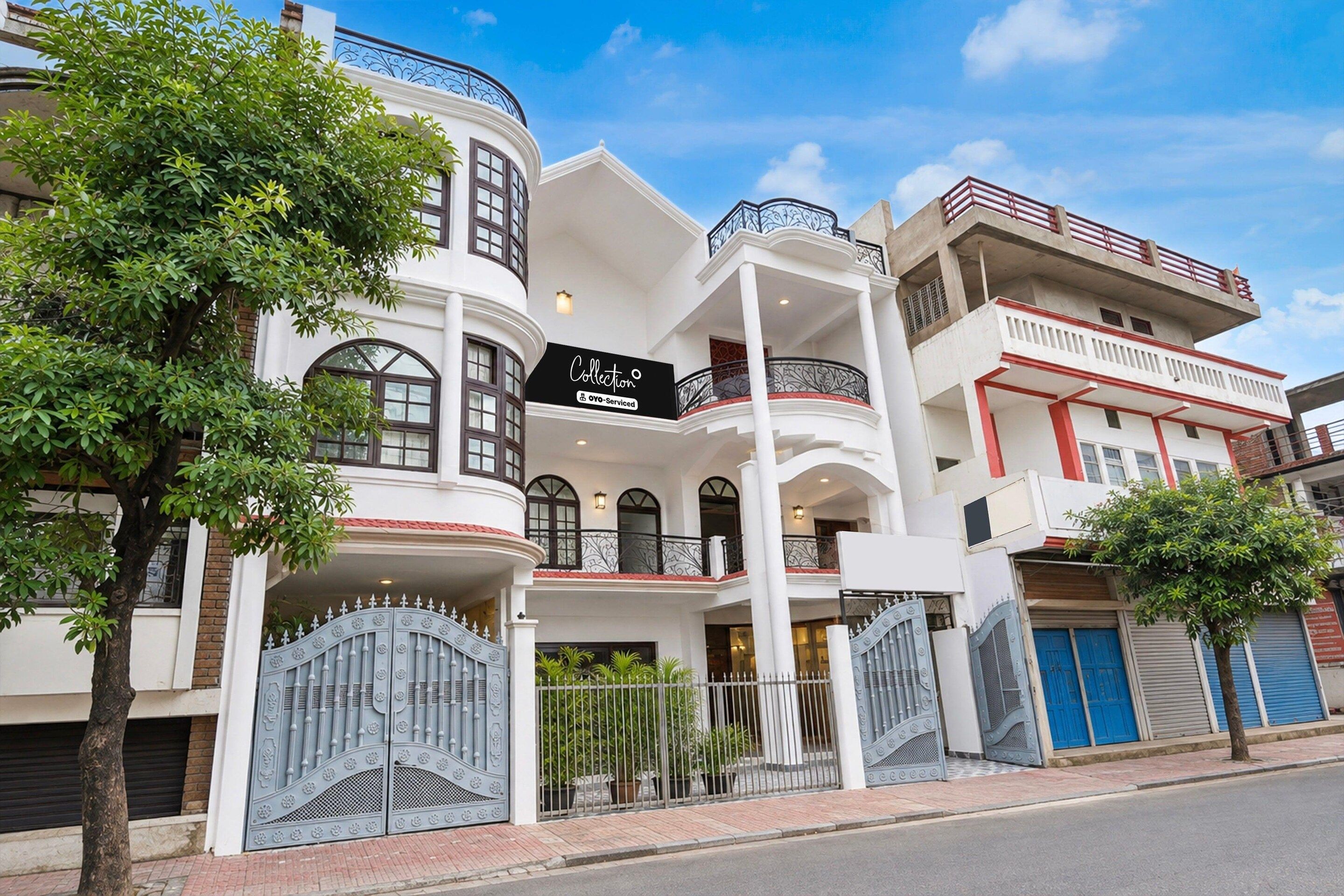 A multi-story building with a prominent 'Collection' sign, featuring balconies and a gated entrance.
