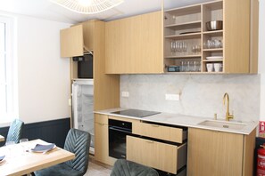 Eine moderne Küche mit Holzausbau, einem eingebauten Backofen und einem Spülbecken mit goldenem Wasserhahn.