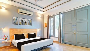 Un dormitorio moderno con cama, mesitas de noche, aire acondicionado instalado en la pared y un ventanal con cortinas.