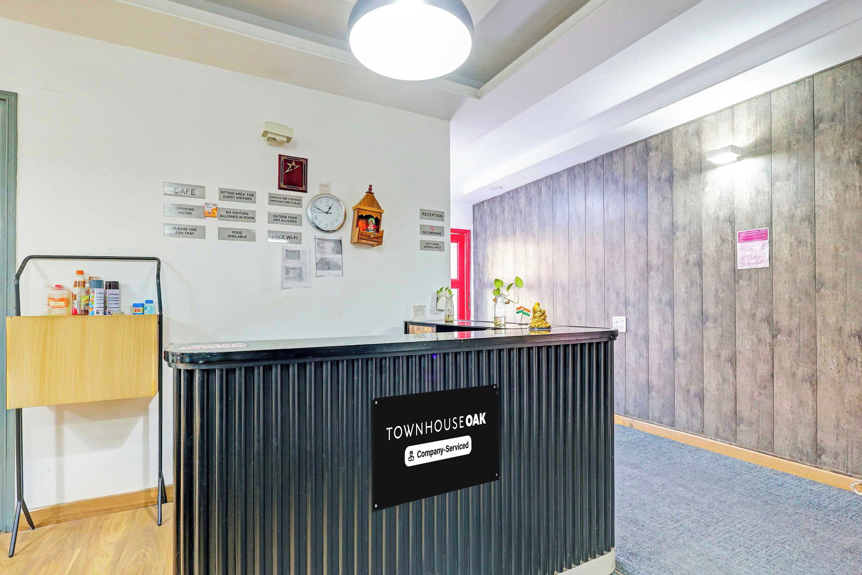 A reception area with a black counter, a clock, and various informational signs on the wall.