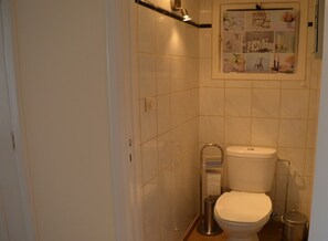 Ein kleines, kompaktes Badezimmer mit Toilette, Bidet und Mülleimer.