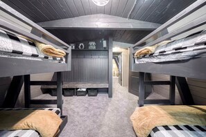 Een slaapkamer met stapelbedden, een centrale opbergruimte en een gang naar andere kamers.