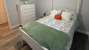 Makuuhuoneessa on sänky, lipasto, yöpöytä ja kattovalaisin.