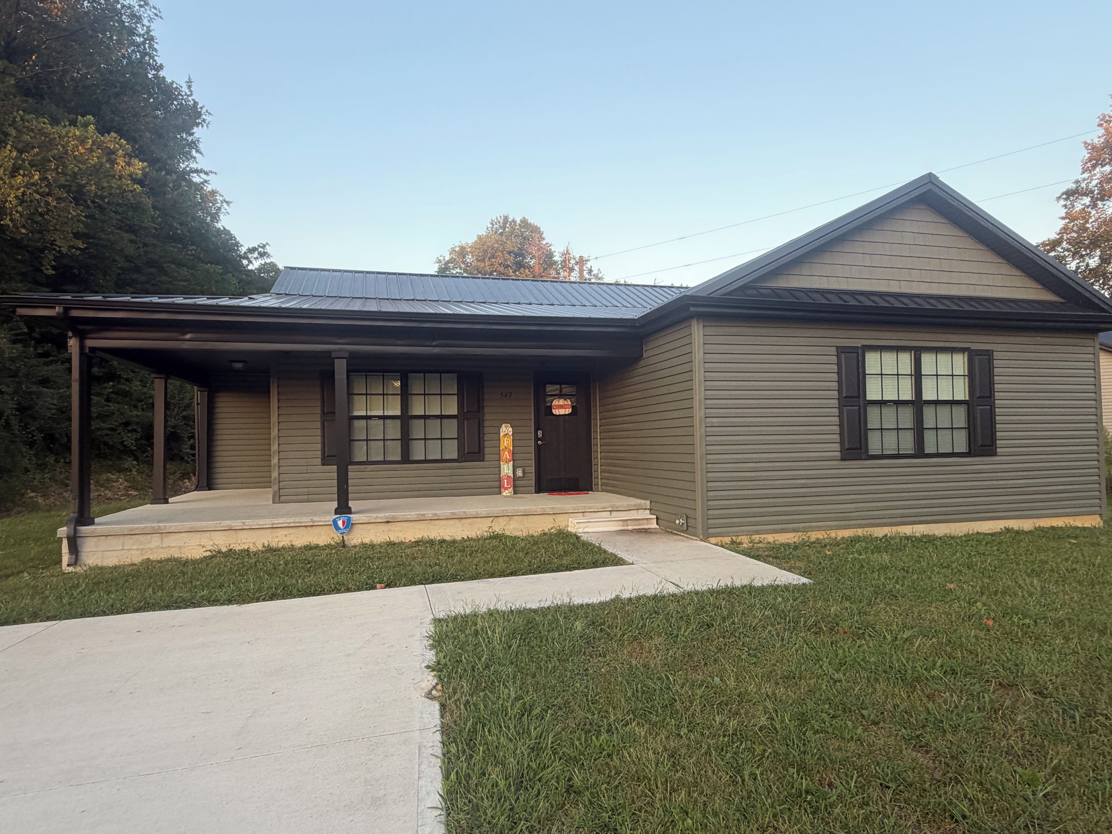 A two-story building with a covered porch, a garage, and a front door.