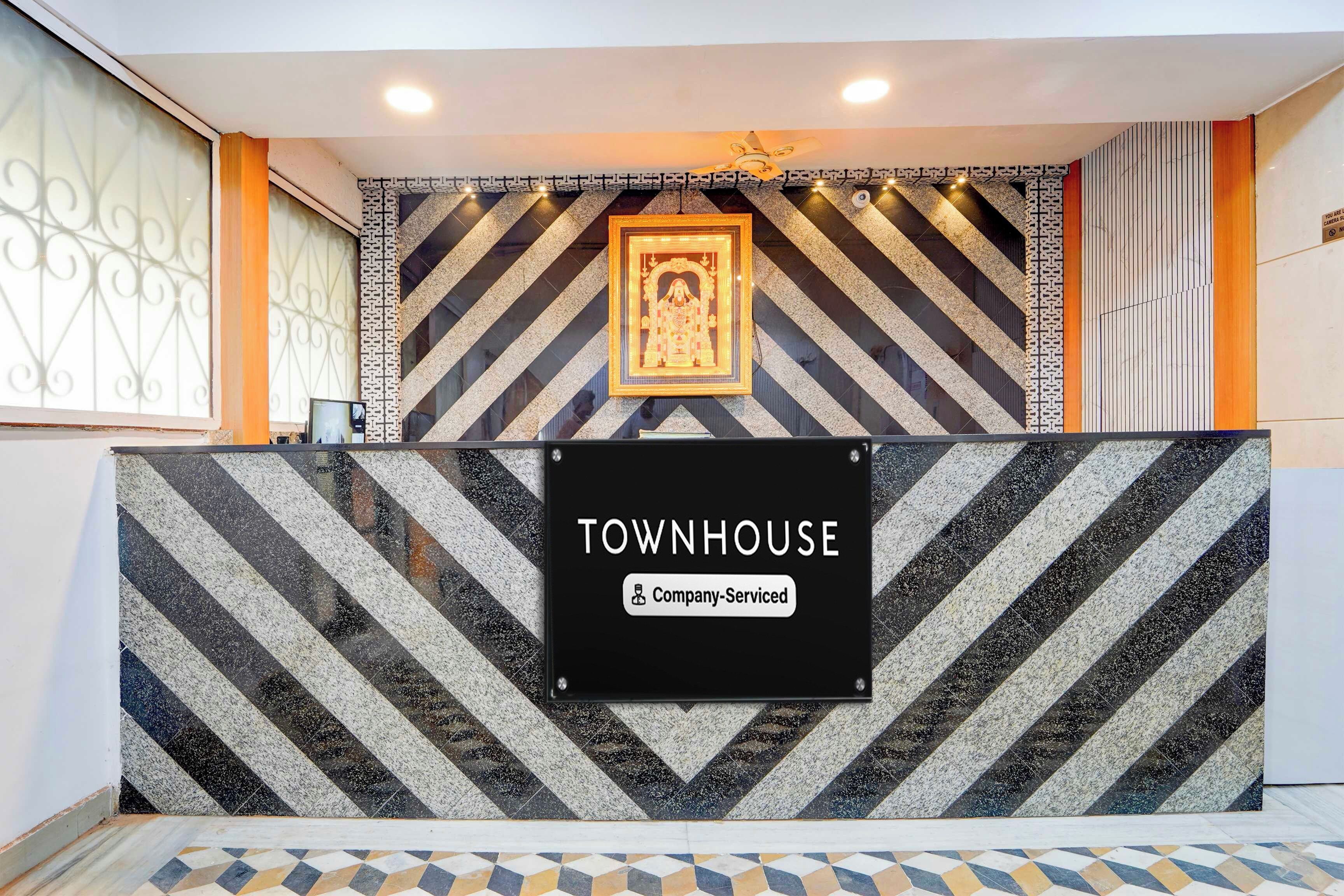 Uma mesa de recepção com uma placa que diz 'TOWNHOUSE Company-Serviced'.