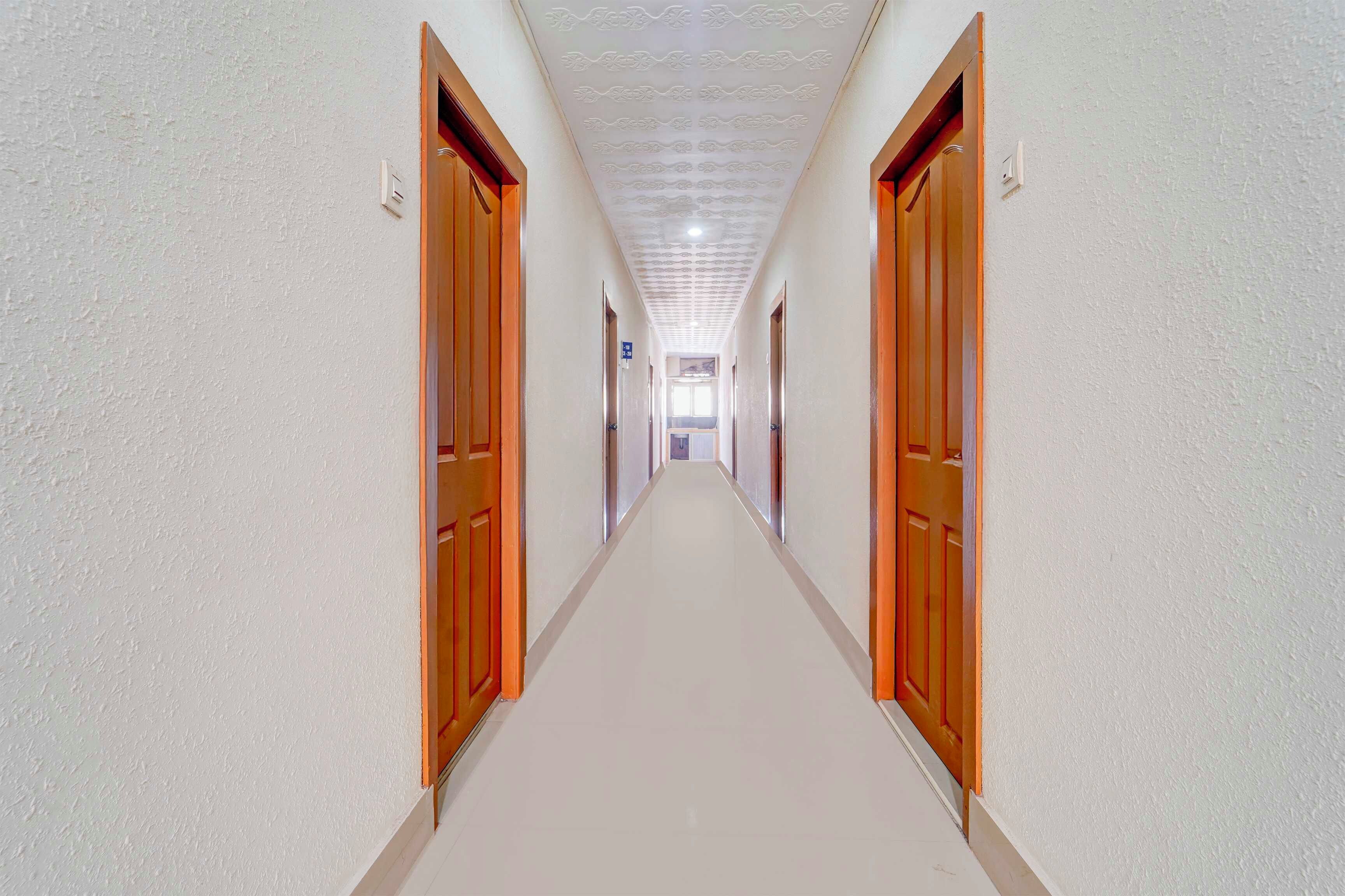 Un passadís llarg i estret amb portes a ambdós costats, que condueix a una habitació al final.