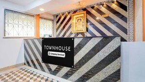 Zona de recepción con un cartel que dice 'TOWNHOUSE Company Serviced'.