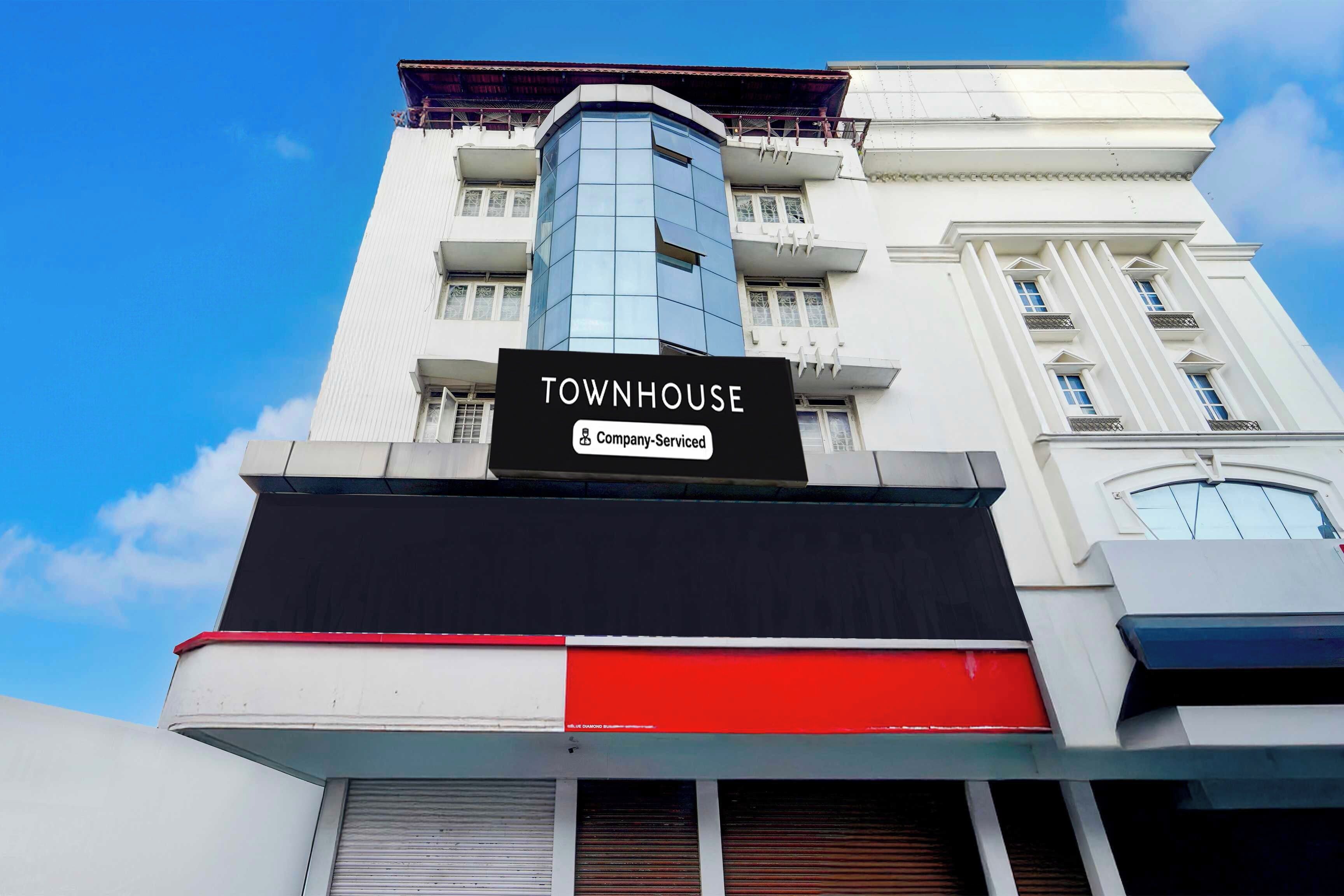 A multi-story building with a prominent sign reading 'TOWNHOUSE Company-Serviced'.