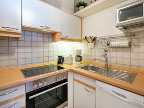 Eine moderne Küche mit Einbauofen, Mikrowelle und Kaffeemaschine.