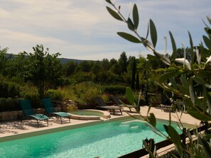 Ein Pool mit Liegestühlen und einer Steinmauer.