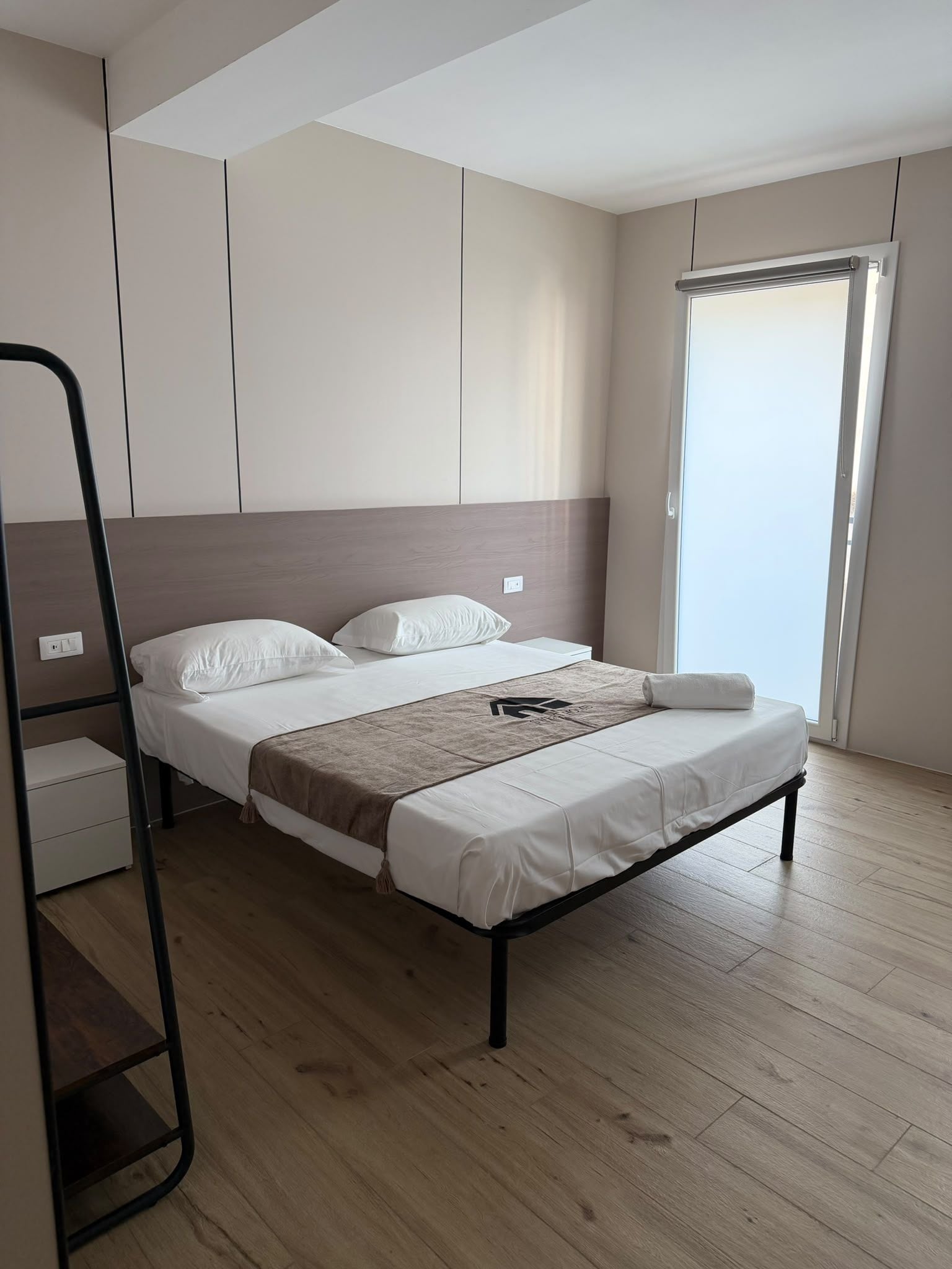 Une chambre à coucher moderne, avec un lit, une armoire et une fenêtre.